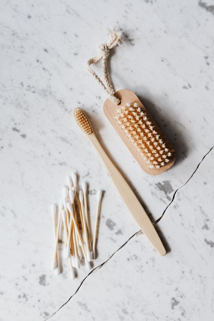 portfolio-03 Top view layout of wooden cleaning brush and cotton swab placed on marble surface near wooden toothbrush on line chop